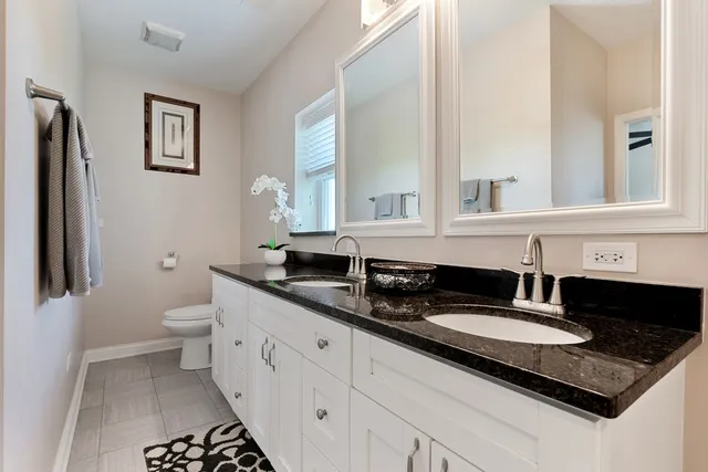 a bathroom with double sink and a mirror