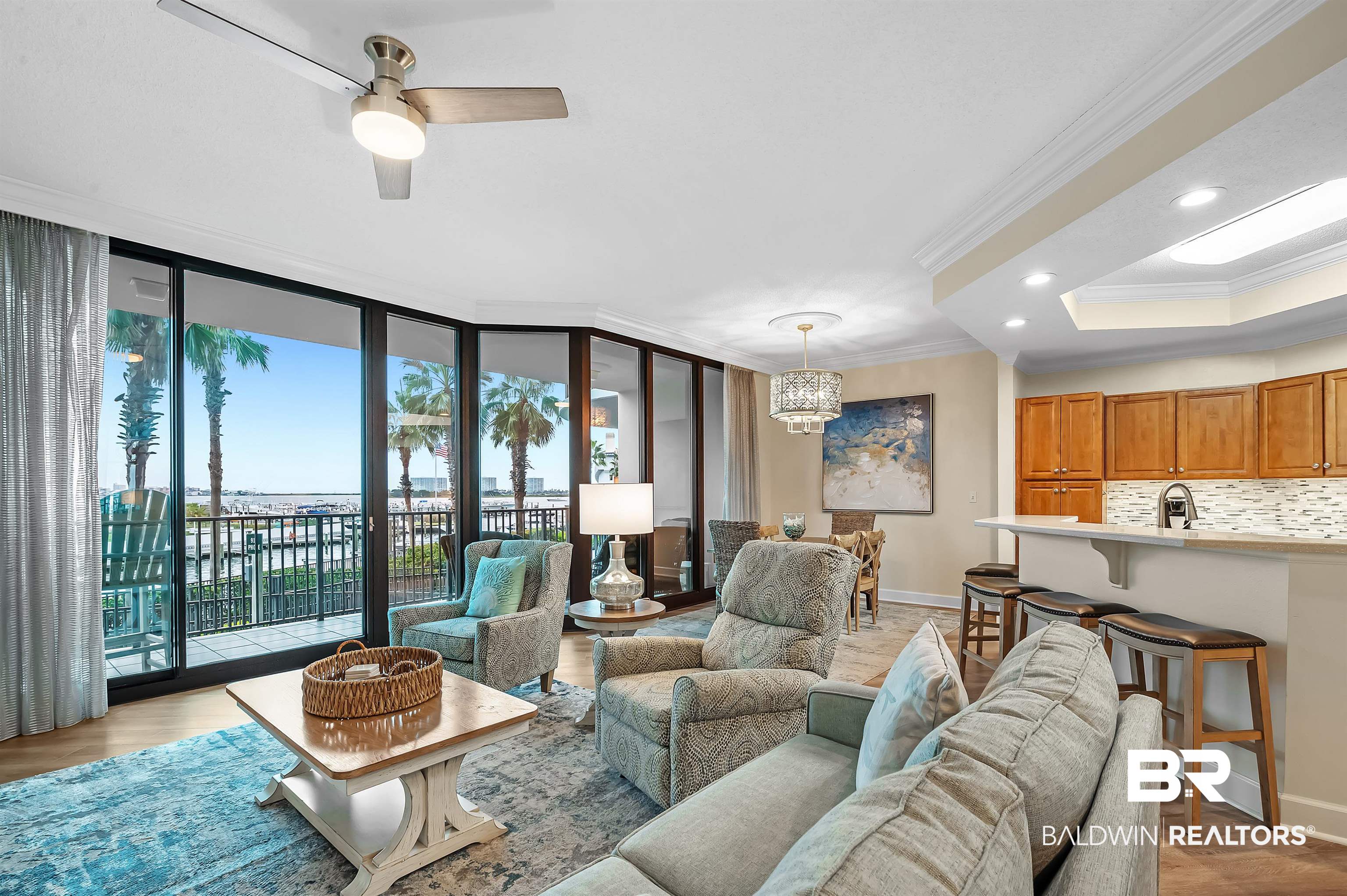 27582 Canal Road, Unit 2104 Orange Beach, AL 36561 - Photo 7 of 35 Living room with expansive windows, light wood-type flooring, ornamental molding, and ceiling fan with notable chandelier