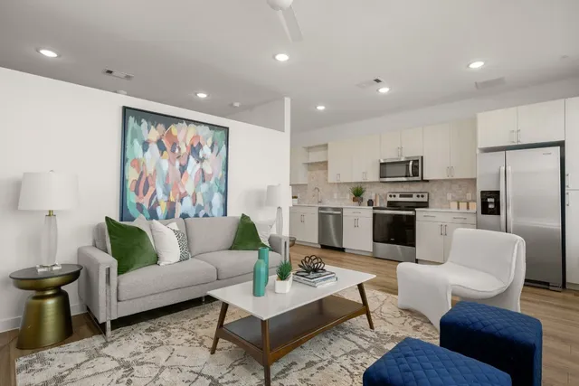 a living room with furniture and kitchen view