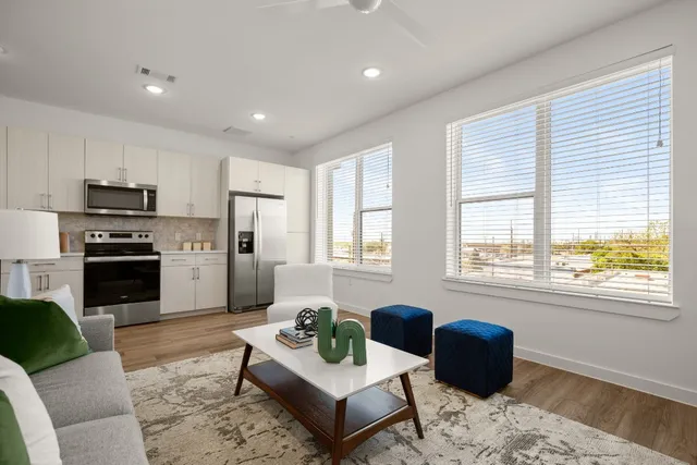 a living room with furniture windows and a kitchen view