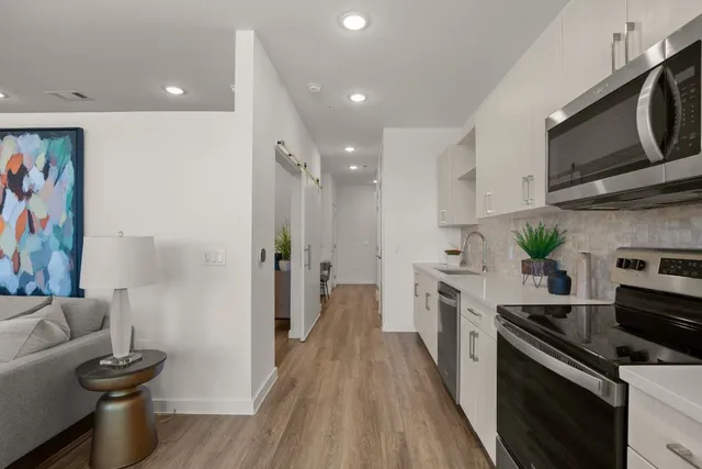a kitchen with stainless steel appliances a stove microwave and sink