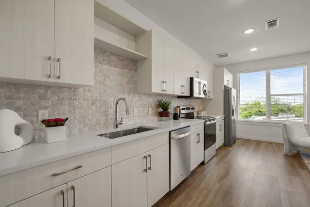 a kitchen with a sink a stove and cabinets