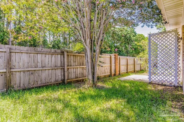 a view of backyard with wooden fence