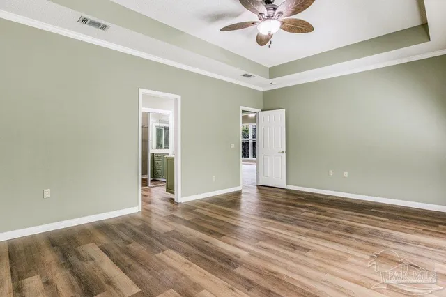 a view of an empty room with window and wooden floor