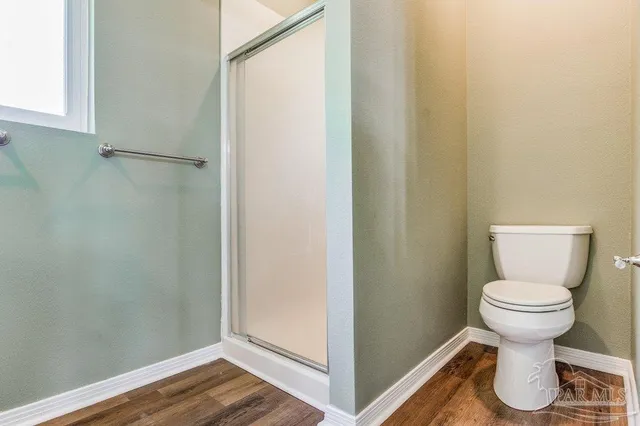 a bathroom with a toilet and a shower