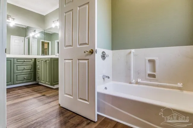 a bathroom with a tub sink and mirror
