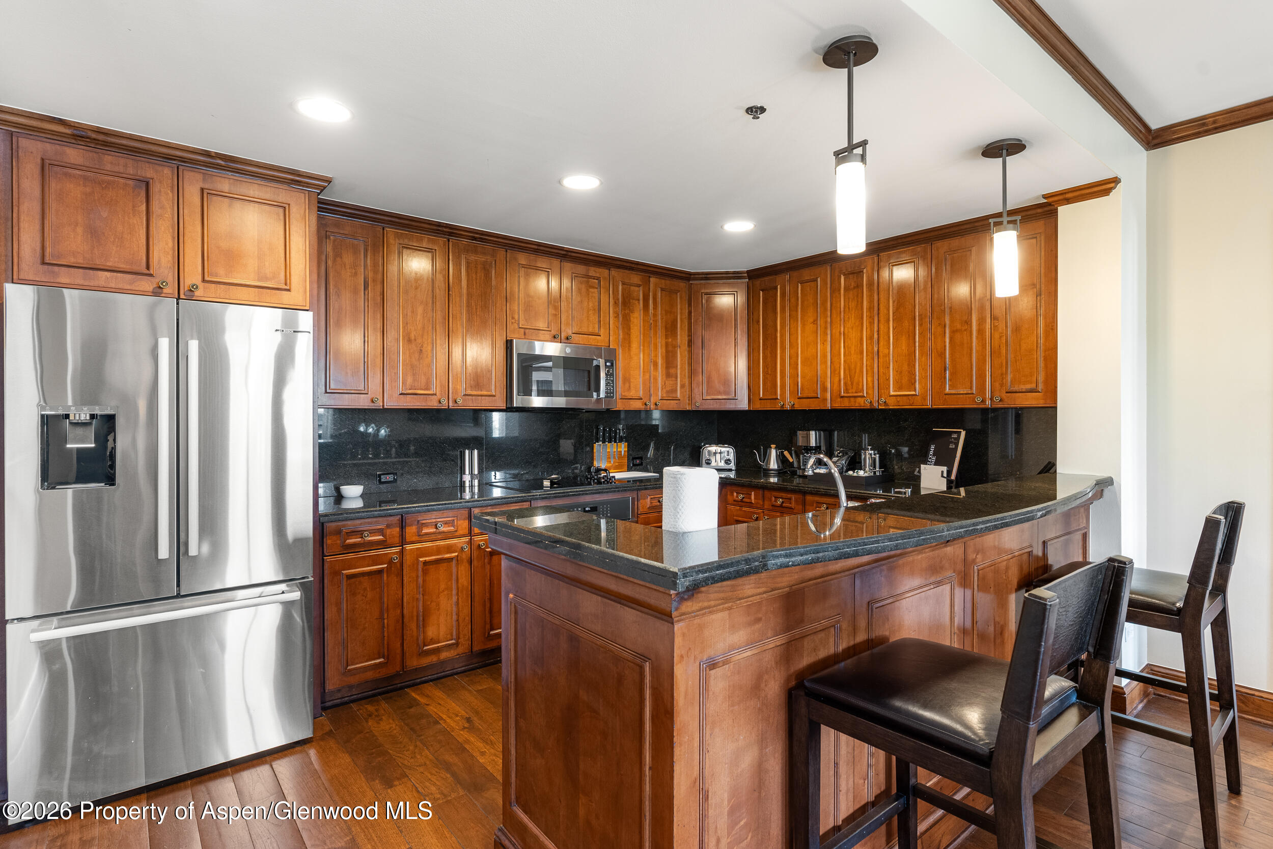 39 Boomerang Road, Unit 8210/WINTER INTEREST 3 Aspen, CO 81611 - Photo 8 of 44 a kitchen with stainless steel appliances granite countertop a refrigerator a sink dishwasher a stove and a refrigerator with wooden floor
