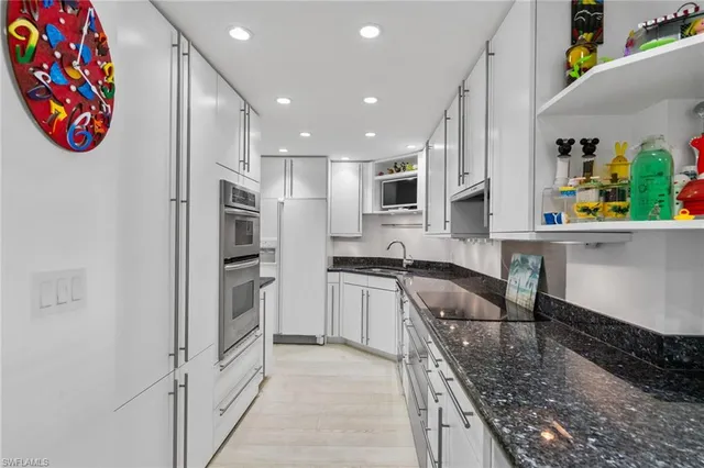 a kitchen with stainless steel appliances granite countertop a refrigerator and a sink