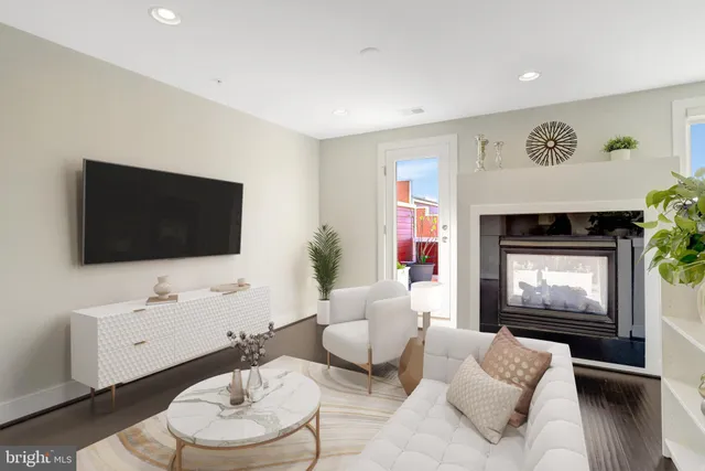 a living room with furniture potted plant and kitchen view
