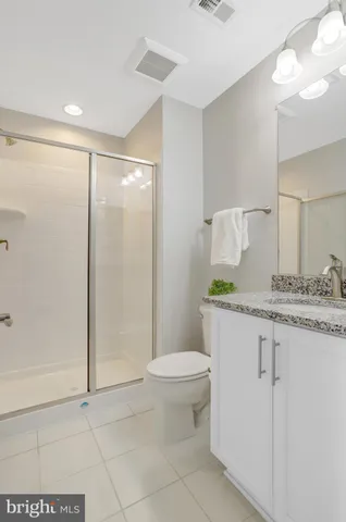 a bedroom with a bed and a flat tv screen on the dresser