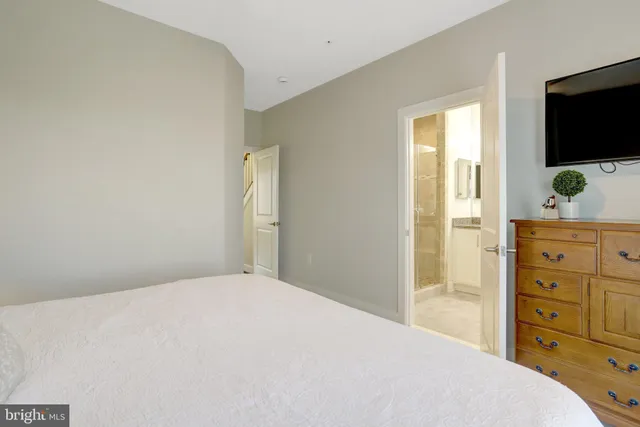 a bedroom with a bed and painting on the wall