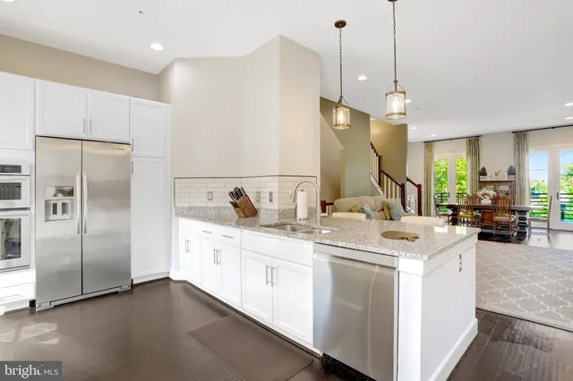 a kitchen with a sink a counter space appliances and cabinets