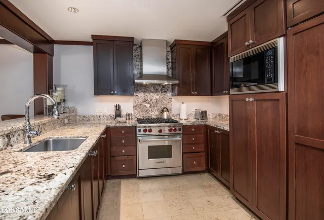a kitchen with stainless steel appliances granite countertop a sink stove and microwave