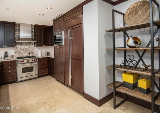a kitchen with stainless steel appliances granite countertop a stove a sink and a refrigerator