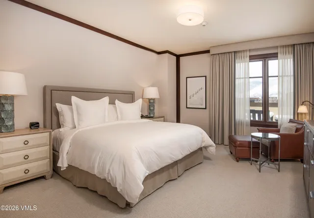 a bedroom with a bed chair and bed