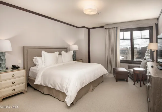 a bedroom with a bed and large windows