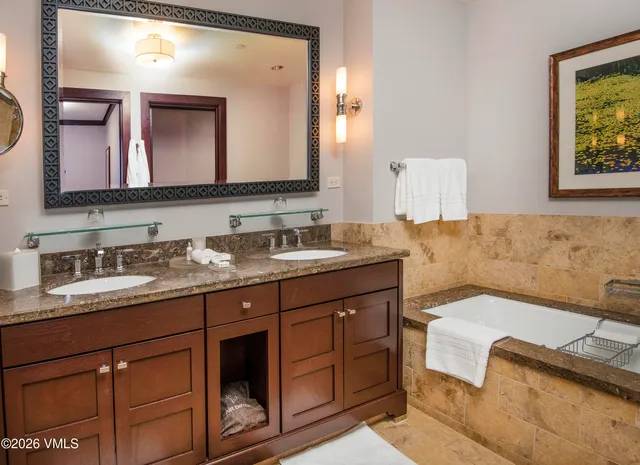a en suite bathroom with a granite countertop sink and a mirror
