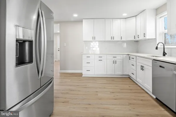 a kitchen with white cabinets and stainless steel appliances