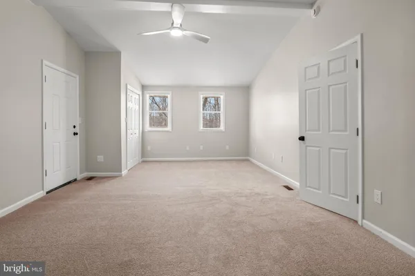a view of a hallway with wooden floor and a window