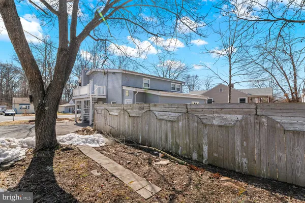 a view of a backyard with wooden fence and large trees