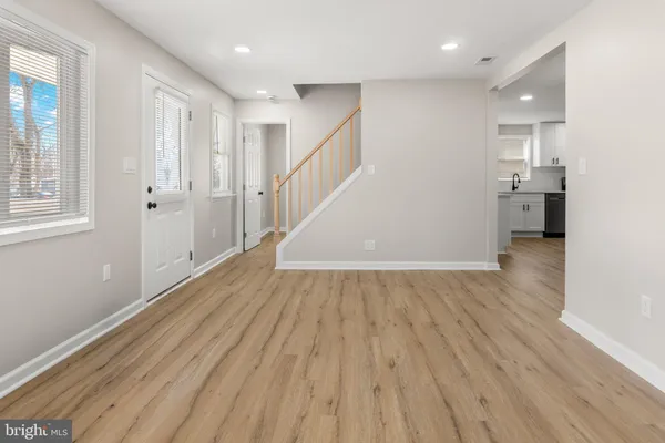 a view of a hallway with wooden floor and staircase