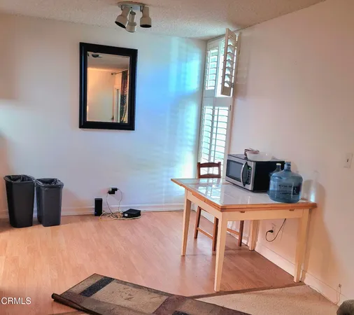 a room with a table chairs and a wooden floor