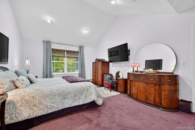 a bedroom with a bed and a flat screen television