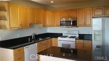 a kitchen with granite countertop a stove a sink and a microwave