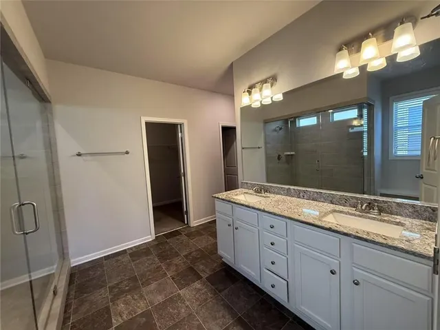 a spacious bathroom with a granite countertop sink mirror and a shower