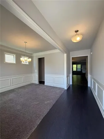 a view of a hallway with wooden floor and a window
