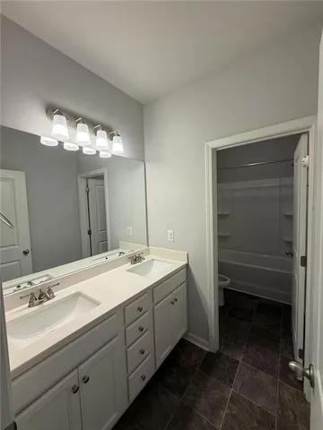 a bathroom with a double vanity sink and a mirror