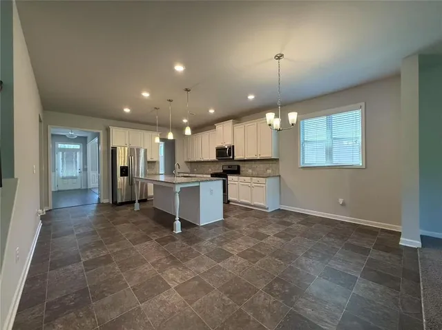 a view of a kitchen with kitchen island wooden floor center island and stainless steel appliances