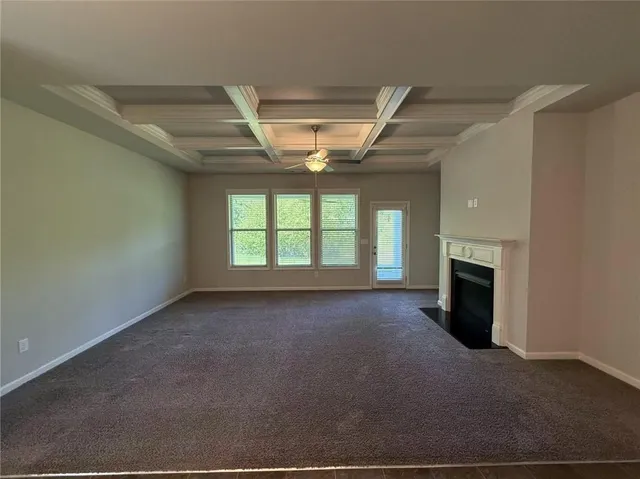 a view of an empty room with a fireplace and a window