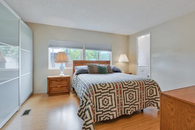 a bedroom with a bed and wooden floor