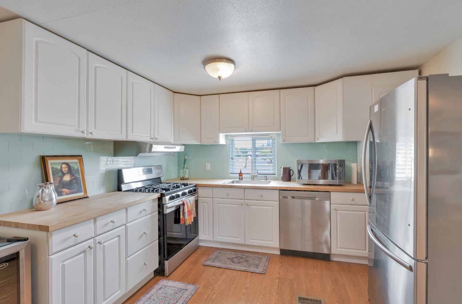 472 Oleander View Way Rancho Cordova, CA 95670 - Photo 8 of 21 a kitchen with stainless steel appliances granite countertop a refrigerator a sink dishwasher a stove top oven a refrigerator and white cabinets with wooden floor