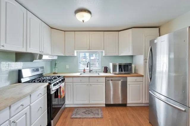 a kitchen with stainless steel appliances granite countertop a refrigerator sink and stove