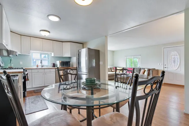 a kitchen with stainless steel appliances granite countertop a dining table and chairs