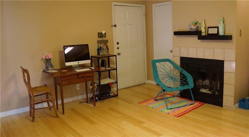 3115 Helms Street, Unit 304 Austin, TX 78705 - Photo 6 of 13 a view of a workspace with furniture and a fireplace