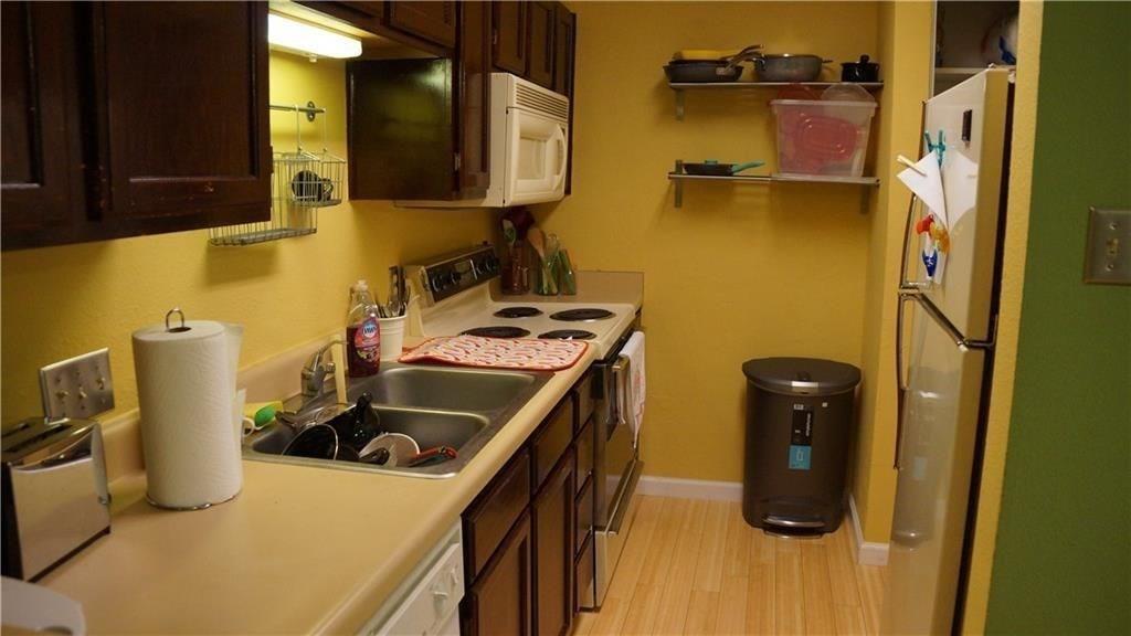3115 Helms Street, Unit 304 Austin, TX 78705 - Photo 8 of 13 a kitchen with a sink and a refrigerator