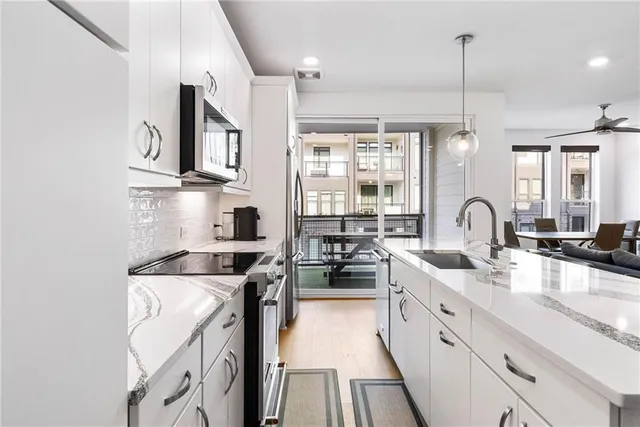 a kitchen with stainless steel appliances granite countertop a stove a sink and a microwave