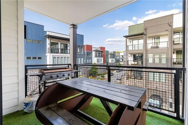 a view of a balcony with two chairs and a barbeque