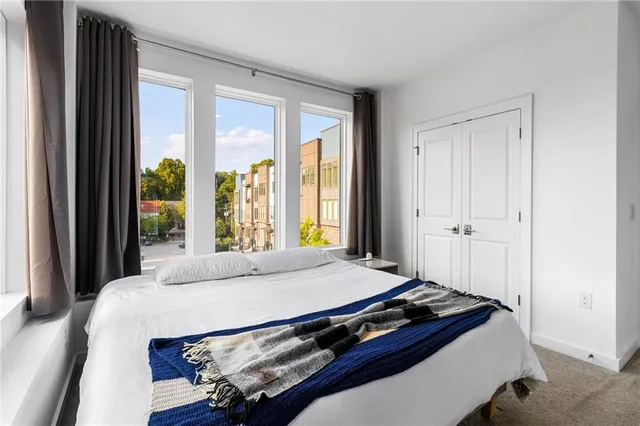 a bedroom with a bed and large window