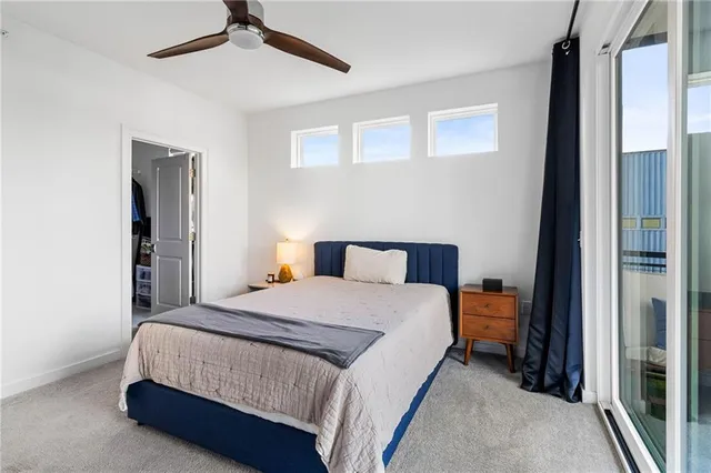 a bedroom with a bed lamp and a ceiling fan