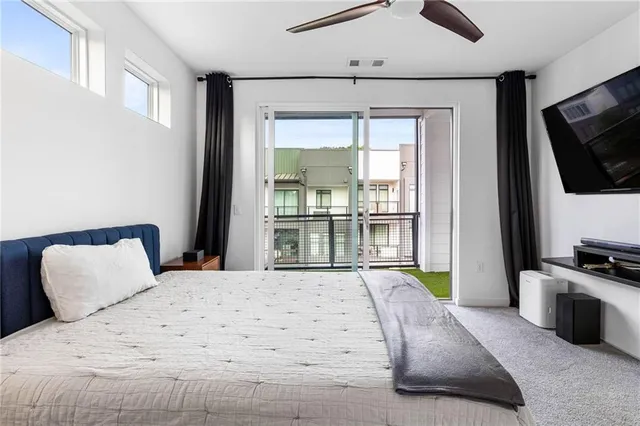 a bedroom with a bed a flat screen tv and a couch