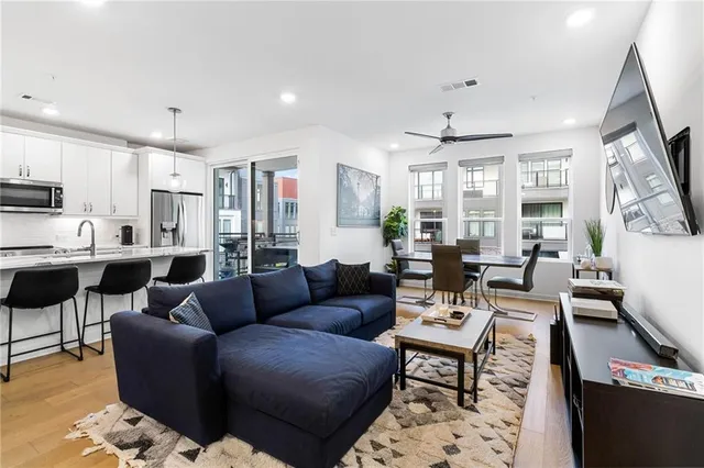 a living room with furniture kitchen and a chandelier
