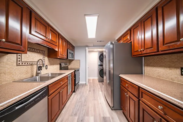 a kitchen with granite countertop stainless steel appliances and wooden cabinets