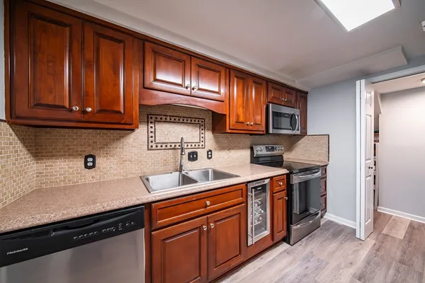 a kitchen with stainless steel appliances a stove a sink and a refrigerator