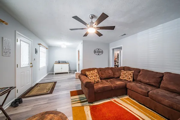 a living room with furniture and a wooden floor