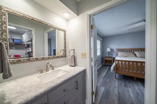 a en suite bathroom with a granite countertop sink and a mirror