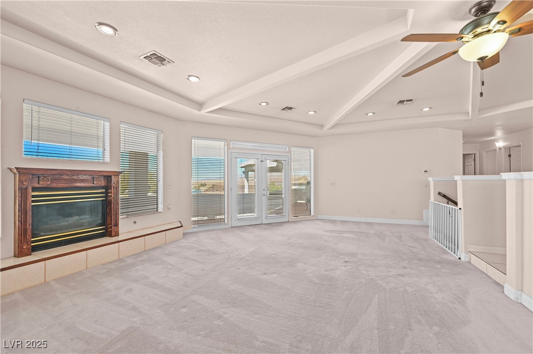 736 Kiel Street Henderson, NV 89015 - Photo 12 of 38 Unfurnished living room with carpet floors, vaulted ceiling with beams, a fireplace, and visible vents
